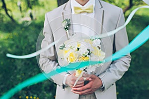 The groom is holding a wedding bouquet