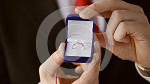 Groom holding wedding ring