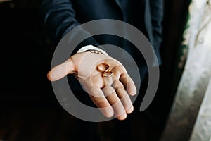 Groom holding wedding rings on the palm, wedding ring in groom hand