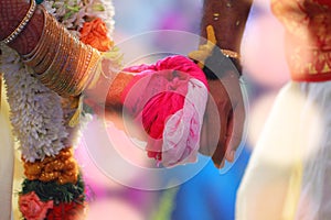 groom holds bride hand in south Indian traditional wedding ceremony with lights