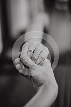Groom holds the bride hand. Wedding rings, engagement ring. Happy woman and girl. Modern black and white photo style