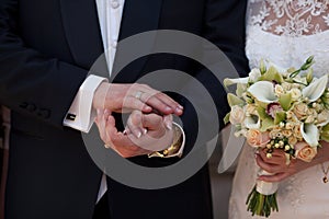 Groom holds bride's arm delicately