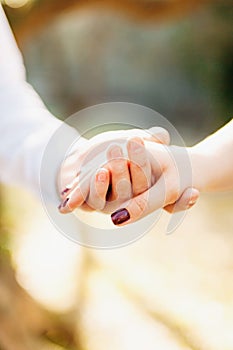 The groom holds the bride's hand, the woman's hand in the man's hand, close-up