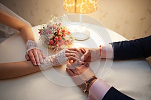 Groom holds his bride's hand at the table