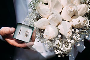 decorative box with wedding rings and a beautiful wedding bouquet of roses for the bride
