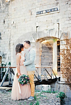 Groom hugs the bride near the bridge to Mamula Fort