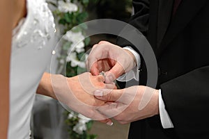 The groom inserting a ring