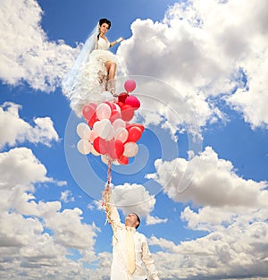 Groom keeps a bride on balloons photo