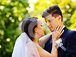 Groom kissing bride outdoor.