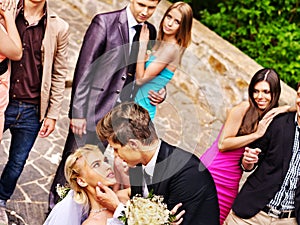 Groom kissing bride in park.