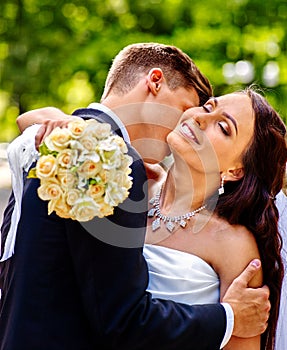 Groom kissing bride on shoulder