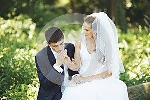 Groom kissing hand of his lovely bride.