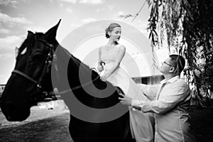 The groom leads the horse by the bridle. Bride sits in the saddl