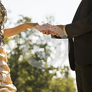 Groom marrying his bride outdoors in a park