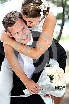 Groom pickaback his bride