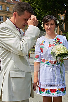 Groom prays,the bride with a bouquet looks at the groom who is baptized with his hand