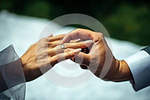 Groom put gold wedding ring on the bride`s finger, close-up. The wedding ceremony, exchange of rings