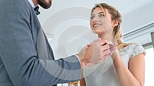 Groom put a ring on finger of his lovely bride in wedding fashion dress up interior studio with wear suit and bride dress