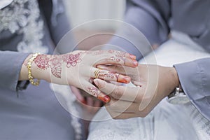 Groom put a wedding ring on bride hand