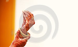 Groom puts bangle in bride hand at bangle ceremony, white background