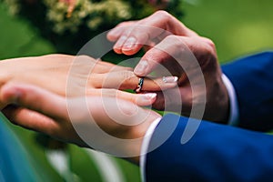 Groom puts the bride a wedding ring of white gold on his finger