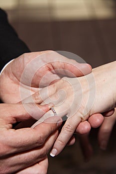 Groom puts ring on Bride