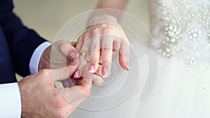 Groom puts ring on the bride, but it is not out. wedding symbols and traditions.