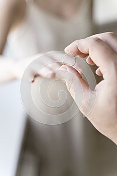 the groom puts the ring on the bride's finger. wedding