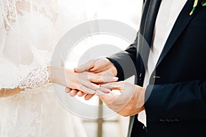 The groom puts the ring on the bride`s finger during the wedding ceremony