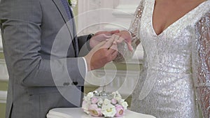 The groom puts a ring on the brides finger at the wedding ceremony. Exchange of rings