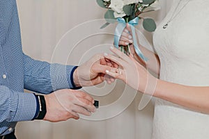 The groom puts the second ring on the brides finger at the wedding ceremony
