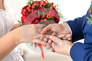 The groom puts a wedding ring on the bride finger. Wedding details