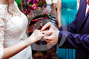 Groom puts wedding ring on bride`s finger