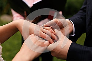 Groom puts wedding ring on bride`s finger