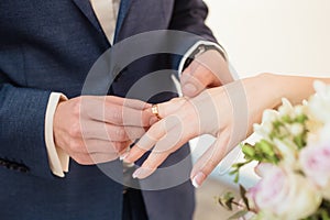 The groom puts the wedding ring on the bride& x27;s finger