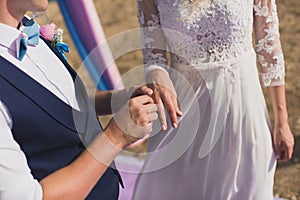 The groom puts the wedding ring on the bride& x27;s finger