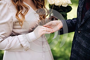The groom puts a wedding ring on the bride`s finger