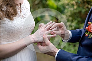 Groom puts a wedding ring on the bride's finger