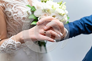 The groom puts a wedding ring on the bride& x27;s finger