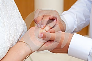 The groom puts the wedding ring on the bride`s finger at the wedding ceremony