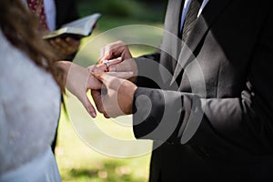 Groom putting engagement ring in woman finger