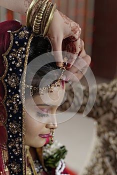 Groom putting Sindoor on Bride's forehead in Indian Hindu wedding.