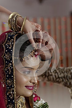 Groom putting Sindoor on Bride's forehead in Indian Hindu wedding. photo