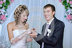 Groom putting a wedding ring on bride finger