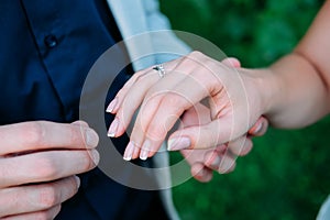 Groom putting on the wedding ring on his bride`s finger