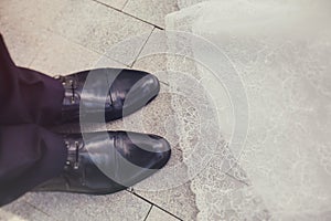 The groom's shoes and the hem of the bride dress closeup