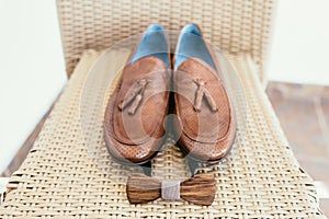 Groom's wedding accessories. Brown shoes and wooden bow-tie