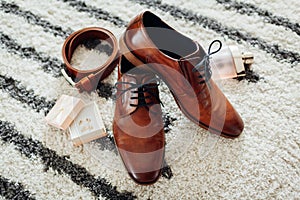 Groom`s wedding day accessories. Brown leather shoes, belt, perfume, golden rings. Male fashion