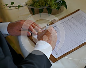 Groom signing for marriage in civil registry office