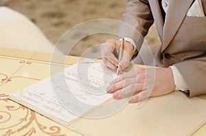 Groom signing marriage license